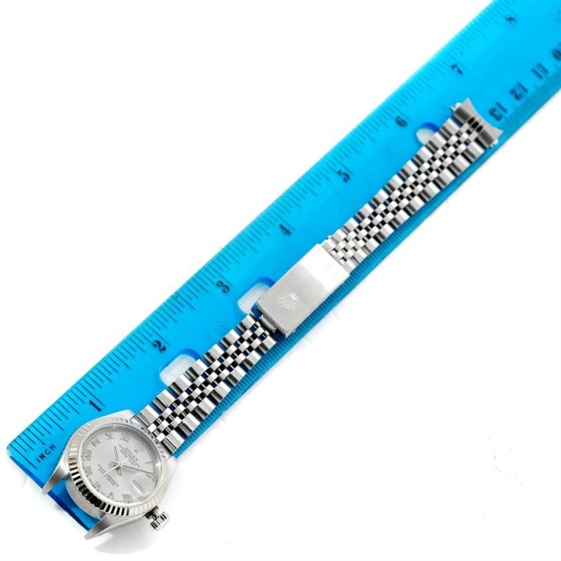 This image shows the Rolex Datejust 79174 Women's Stainless Steel Silver Dial 79174 Women's Stainless Steel Silver Dial watch laid flat next to a blue ruler, highlighting the face and bracelet.