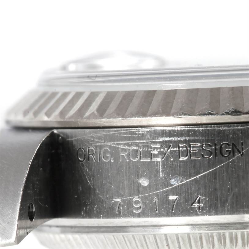 This close-up image of the Rolex Datejust 79174 Women's Stainless Steel Silver Dial 79174 Women's Stainless Steel Silver Dial watch features the case side, showing the engraved model number 79174 and "ORIG. ROLEX DESIGN."
