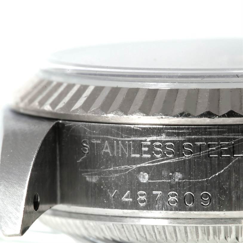The image shows a close-up of the side of a Rolex Datejust 79174 Women's Stainless Steel Silver Dial 79174 Women's Stainless Steel Silver Dial watch, focusing on the engraving on its stainless steel case and bezel.
