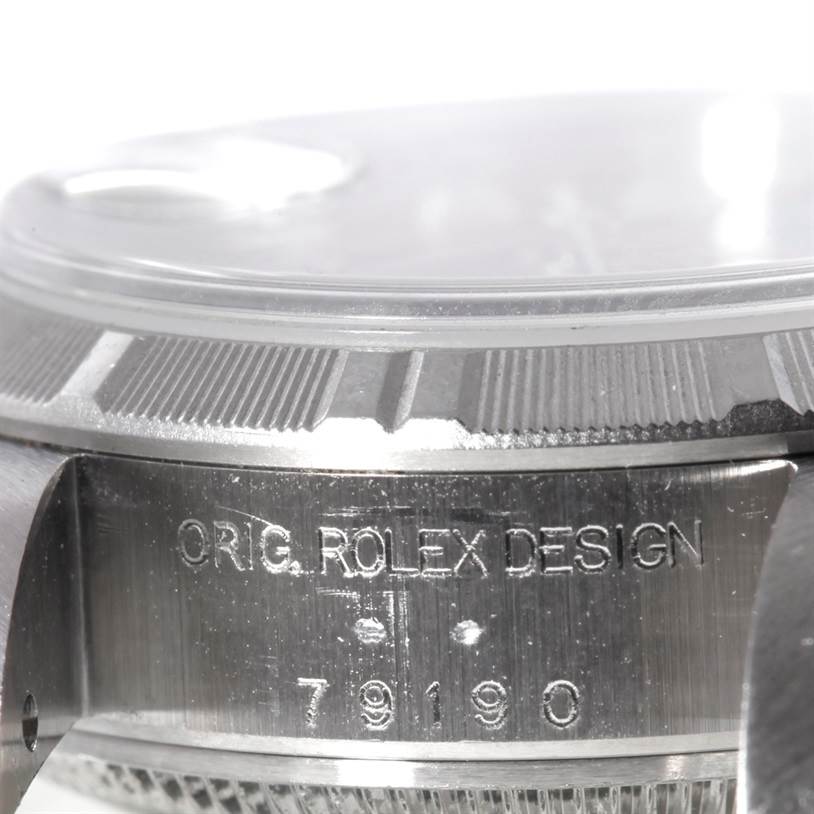 This image shows a close-up angled view of the case side of a Rolex Datejust 79190 Women's Stainless Steel Blue Dial 79190 Women's Stainless Steel Blue Dial watch, featuring engraved text "ORIG. ROLEX DESIGN" and the model number "79190".