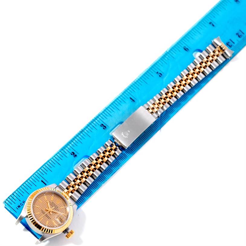 The image shows a top view of a Rolex Datejust 69173 Women's Stainless Steel Champagne Dial 69173 Women's Stainless Steel Champagne Dial watch with its face, bezel, and bracelet alongside a ruler for measurement.