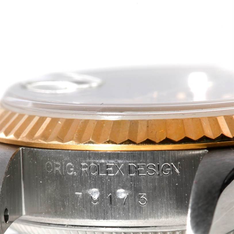 This image shows a close-up side view of the Rolex Datejust 79173 Women's Stainless Steel Champagne Dial 79173 Women's Stainless Steel Champagne Dial model's fluted bezel, crystal, and the engraved case.