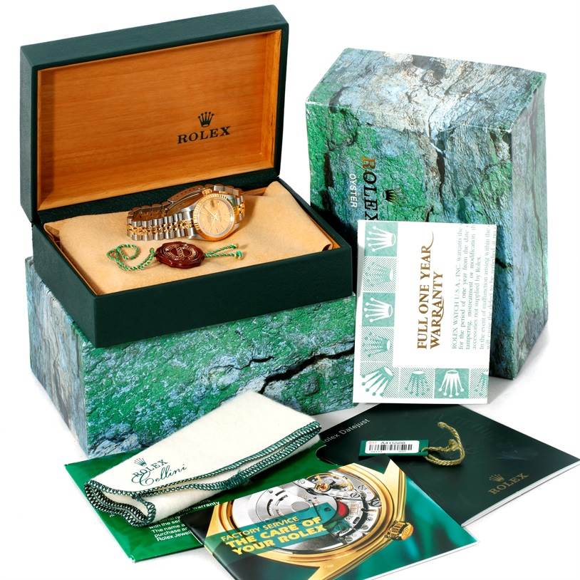 The Rolex Datejust 79173 Women's Stainless Steel Champagne Dial 79173 Women's Stainless Steel Champagne Dial watch is shown in an open box with a warranty card, manuals, and a cleaning cloth.