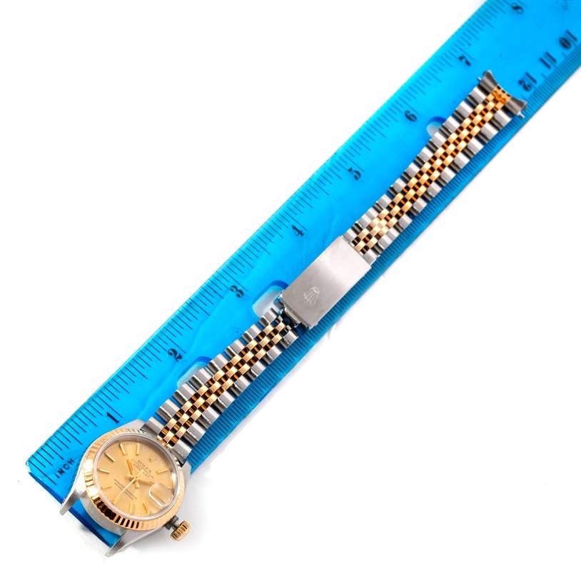 This image shows a Rolex Datejust 69173 Women's Stainless Steel Champagne Dial 69173 Women's Stainless Steel Champagne Dial watch from an overhead angle, including its dial, bracelet, and clasp, with a ruler beside it.