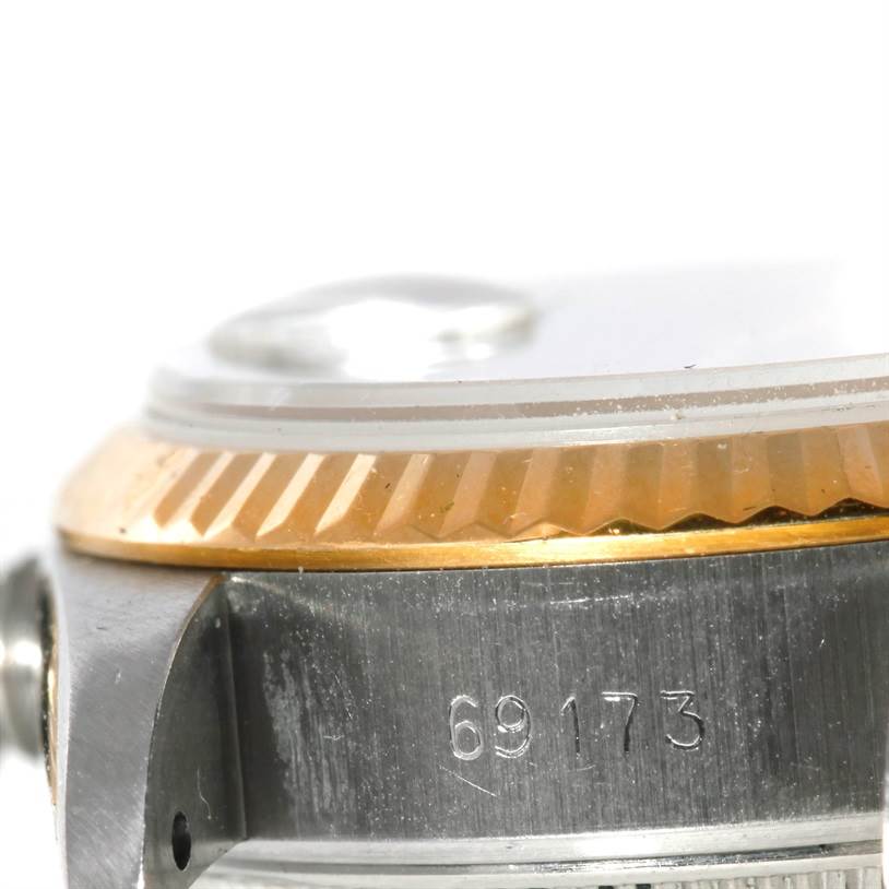 This close-up image of a Rolex Datejust 69173 Women's Stainless Steel Champagne Dial 69173 Women's Stainless Steel Champagne Dial watch displays the model number, part of the bezel, and the case edge.