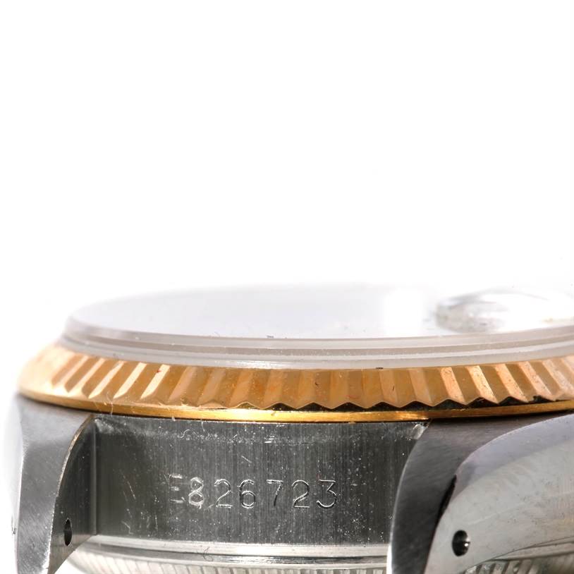 This image shows a close-up of the side of a Rolex Datejust 69173 Women's Stainless Steel Champagne Dial 69173 Women's Stainless Steel Champagne Dial watch, highlighting the bezel, crystal, and part of the serial number.