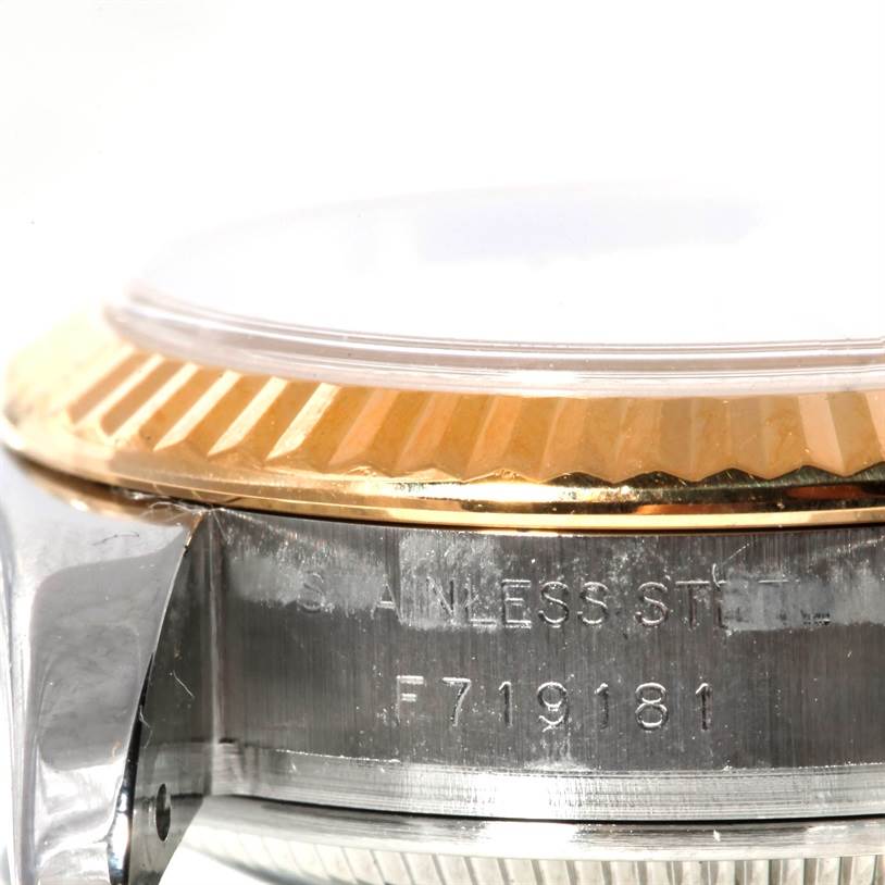 This close-up angle of the Rolex Datejust 179173 Women's Steel and Gold (two tone) Mother of Pearl Dial 179173 Women's Steel and Gold (two tone) Mother of Pearl Dial model shows part of the bezel, the case side, and the serial number engraving.