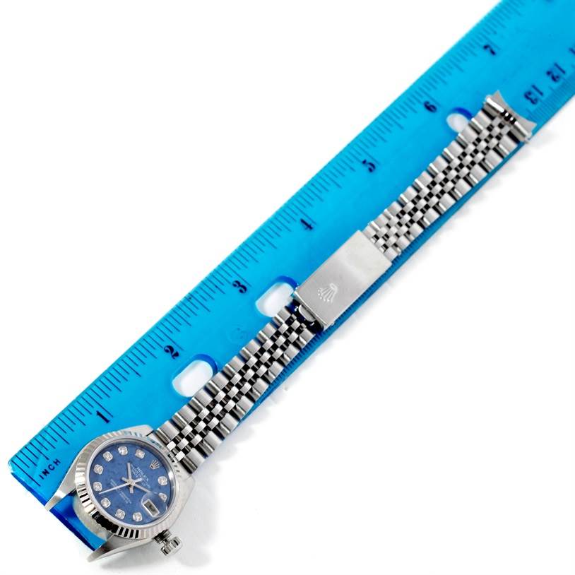 The Rolex Datejust 79174 Women's Stainless Steel Blue Dial 79174 Women's Stainless Steel Blue Dial watch is shown horizontally with a blue ruler measuring its length, including the face and band.