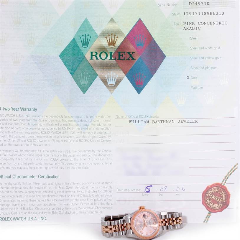 The image shows a Rolex Datejust 179171 Women's Steel and Gold (two tone) Pink Dial 179171 Women's Steel and Gold (two tone) Pink Dial watch positioned on its side along with its warranty certificate and chronometer certification.