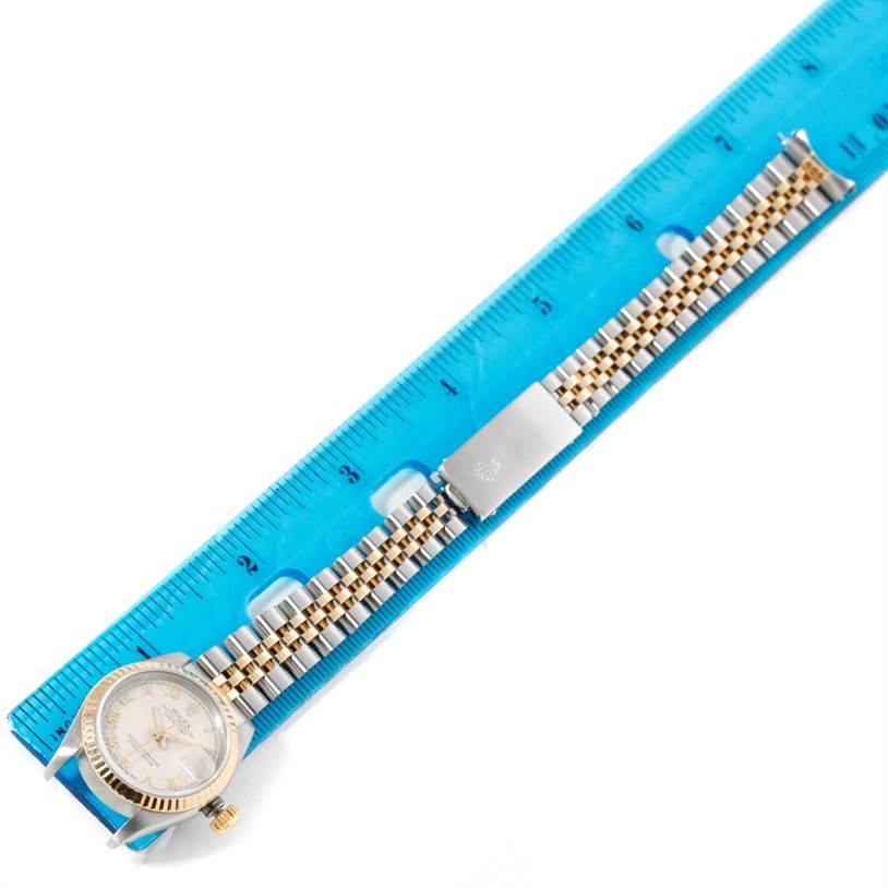 The image shows a Rolex Datejust 69173 Women
s Stainless Steel Beige Dial 69173 Women
s Stainless Steel Beige Dial watch placed next to a ruler, displaying its face, bezel, and two-tone bracelet.