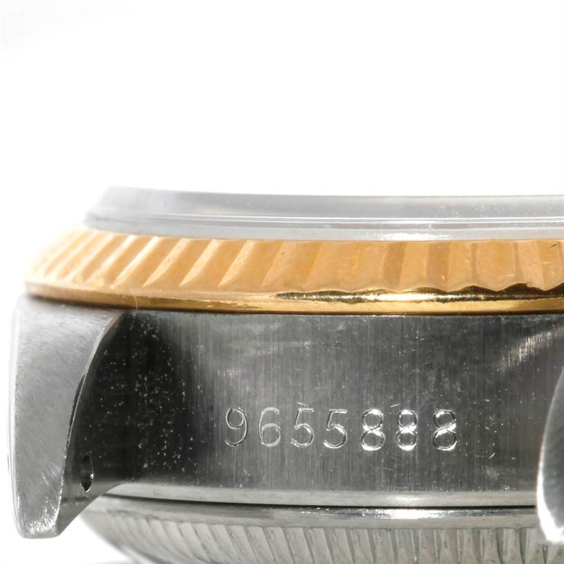 This image shows a close-up angle of a Rolex Datejust 69173 Women
s Stainless Steel Beige Dial 69173 Women
s Stainless Steel Beige Dial watch, focusing on its case, bezel, and serial number.