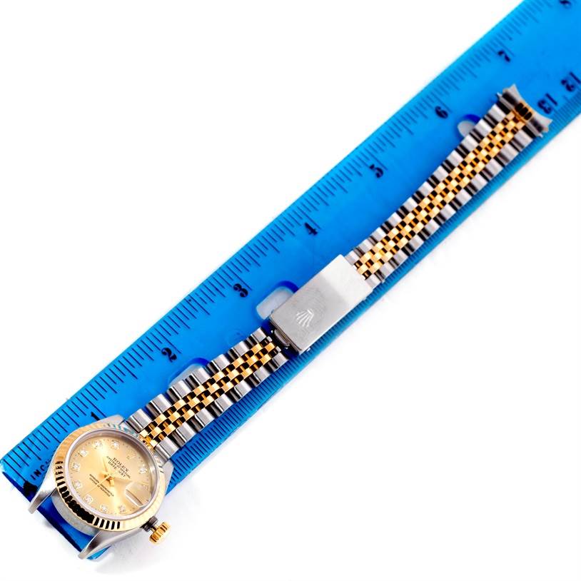 The image shows the Rolex Datejust 69173 Women's Stainless Steel Champagne Dial 69173 Women's Stainless Steel Champagne Dial watch laid flat next to a blue ruler, displaying its band and part of its face.