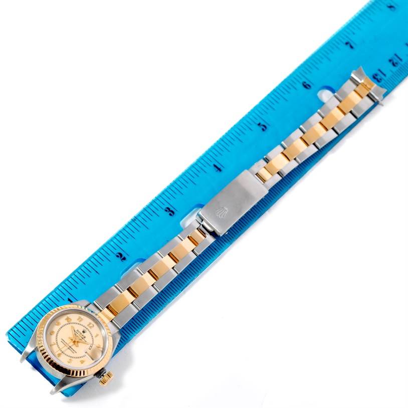 This image shows a Rolex Datejust 69173 Men's Stainless Steel Beige Dial 69173 Men's Stainless Steel Beige Dial watch and its bracelet, laid flat alongside a blue ruler, highlighting its size.