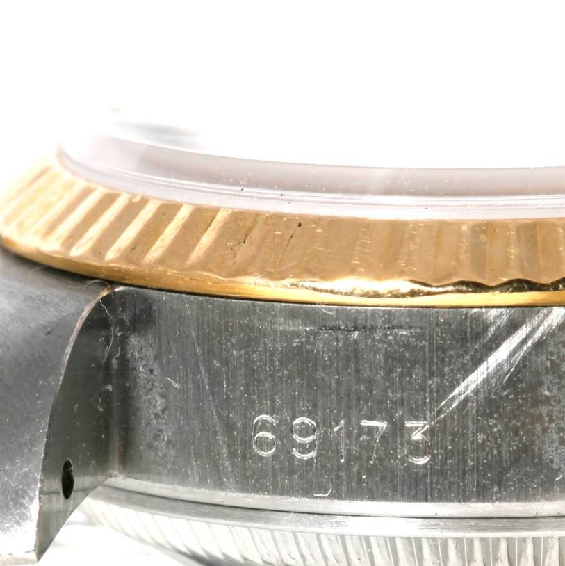 This close-up image of the Rolex Datejust 69173 Men's Stainless Steel Beige Dial 69173 Men's Stainless Steel Beige Dial model shows the serial number, bezel, and part of the watch case.