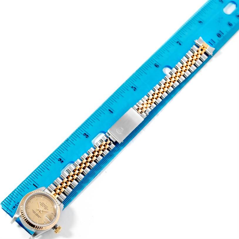 The image shows a Rolex Datejust 69173 Women's Stainless Steel Champagne Dial 69173 Women's Stainless Steel Champagne Dial watch laid flat beside a blue ruler, displaying its gold and silver bracelet and face.