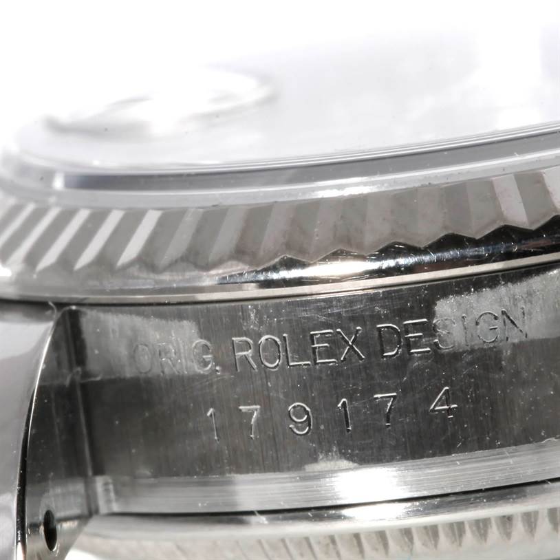 The image shows a close-up of the Rolex Datejust 179174 Women's Stainless Steel Silver Dial 179174 Women's Stainless Steel Silver Dial model's case and engraved serial number on the side.