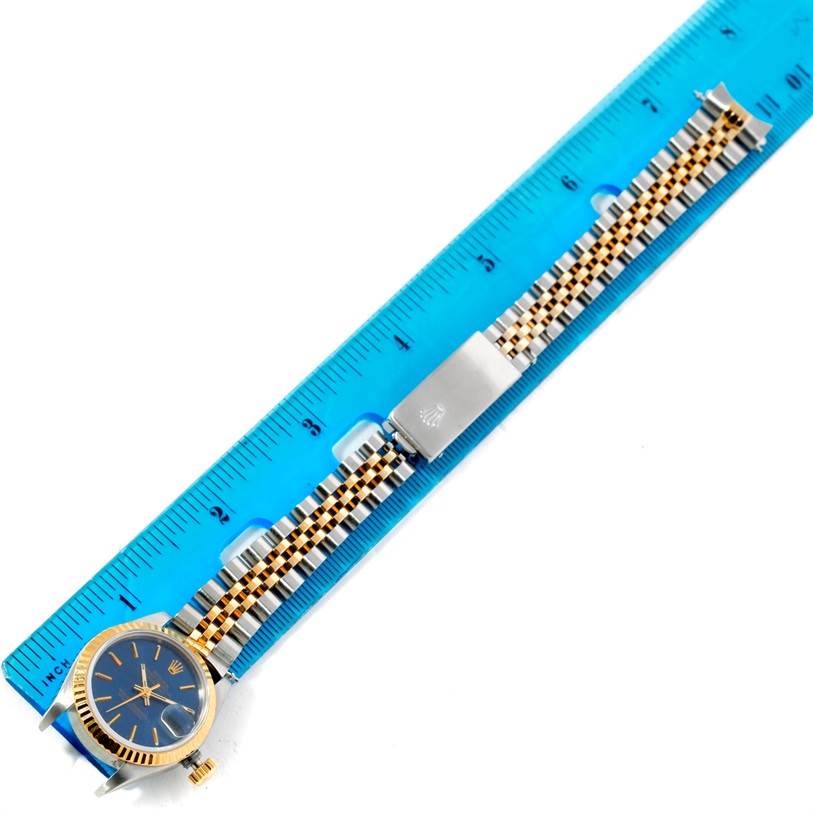 The image shows a Rolex Datejust 69173 Women's Stainless Steel Blue Dial 69173 Women's Stainless Steel Blue Dial watch and its two-tone bracelet, placed alongside a blue measuring ruler.