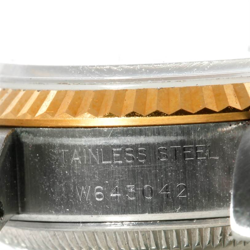 This close-up image shows the side view of a Rolex Datejust 69173 Women's Stainless Steel Blue Dial 69173 Women's Stainless Steel Blue Dial model's case, focusing on the engraved serial number and part of the fluted bezel.