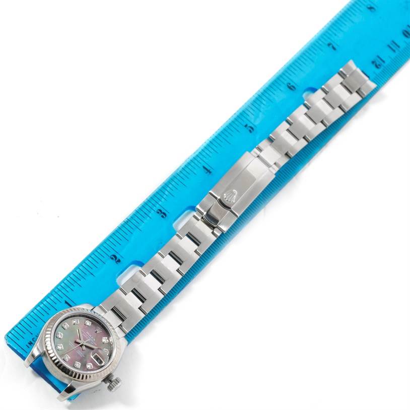 The image shows a Rolex Datejust 179174 Women's Stainless Steel Mother of Pearl Dial 179174 Women's Stainless Steel Mother of Pearl Dial watch laid flat next to a ruler, displaying the watch face and metal bracelet.