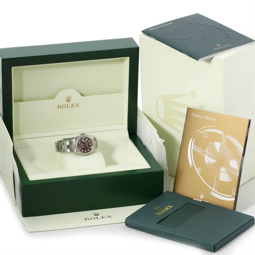 The Rolex Datejust 179174 Women's Stainless Steel Mother of Pearl Dial 179174 Women's Stainless Steel Mother of Pearl Dial watch is shown at an angle inside its green box, accompanied by booklets and outer packaging.