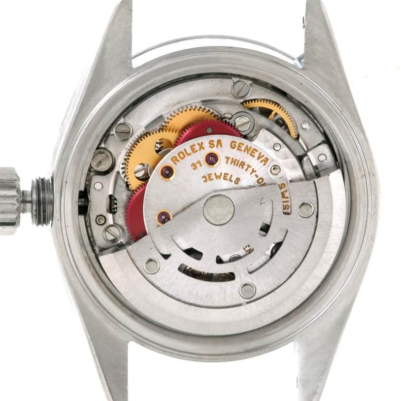 The image shows the internal mechanism of a Rolex Datejust 79190 Women's Stainless Steel White Dial 79190 Women's Stainless Steel White Dial watch from a top-down angle, highlighting gears and inscriptions.