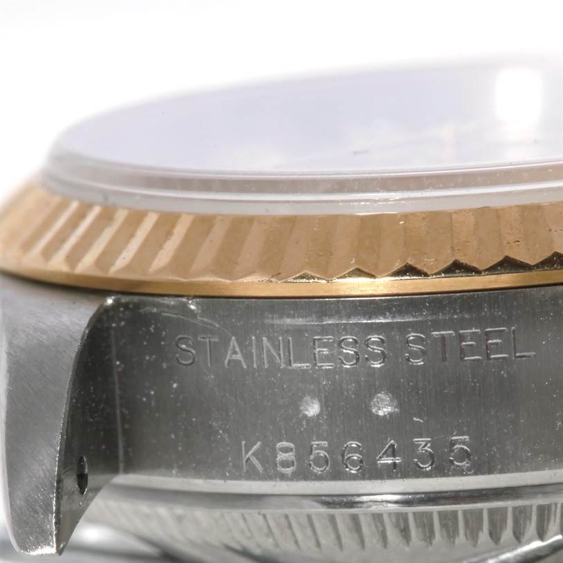 The image displays a close-up of the side of a Rolex Datejust 79173 Women's Stainless Steel Champagne Dial 79173 Women's Stainless Steel Champagne Dial watch, showing the stainless steel case and part of the gold bezel.