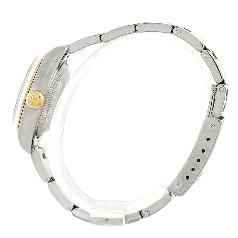 This side view of the Rolex Datejust 79163 Women's Steel and Gold (two tone) Black Dial 79163 Women's Steel and Gold (two tone) Black Dial watch shows the crown, case, and metal bracelet.