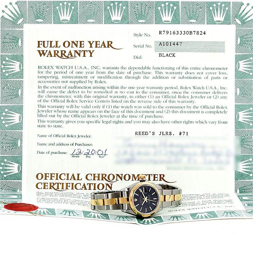 The image shows a front view of a Rolex Datejust 79163 Women's Steel and Gold (two tone) Black Dial 79163 Women's Steel and Gold (two tone) Black Dial watch positioned over an official warranty document.
