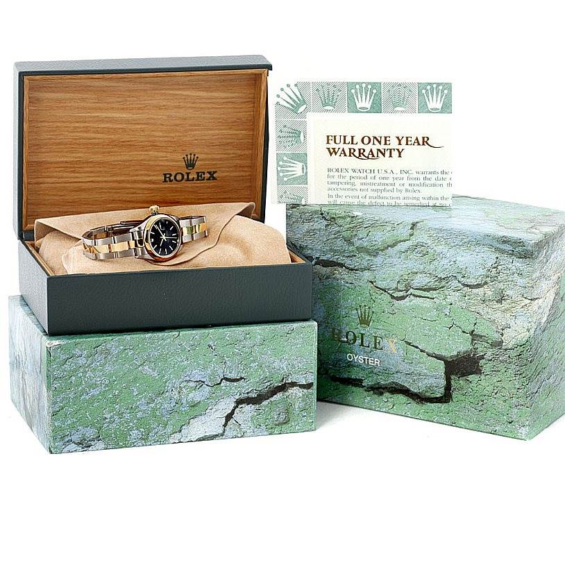 The image shows a Rolex Datejust 79163 Women's Steel and Gold (two tone) Black Dial 79163 Women's Steel and Gold (two tone) Black Dial watch with its box, outer box, and warranty card displayed at an angled view.