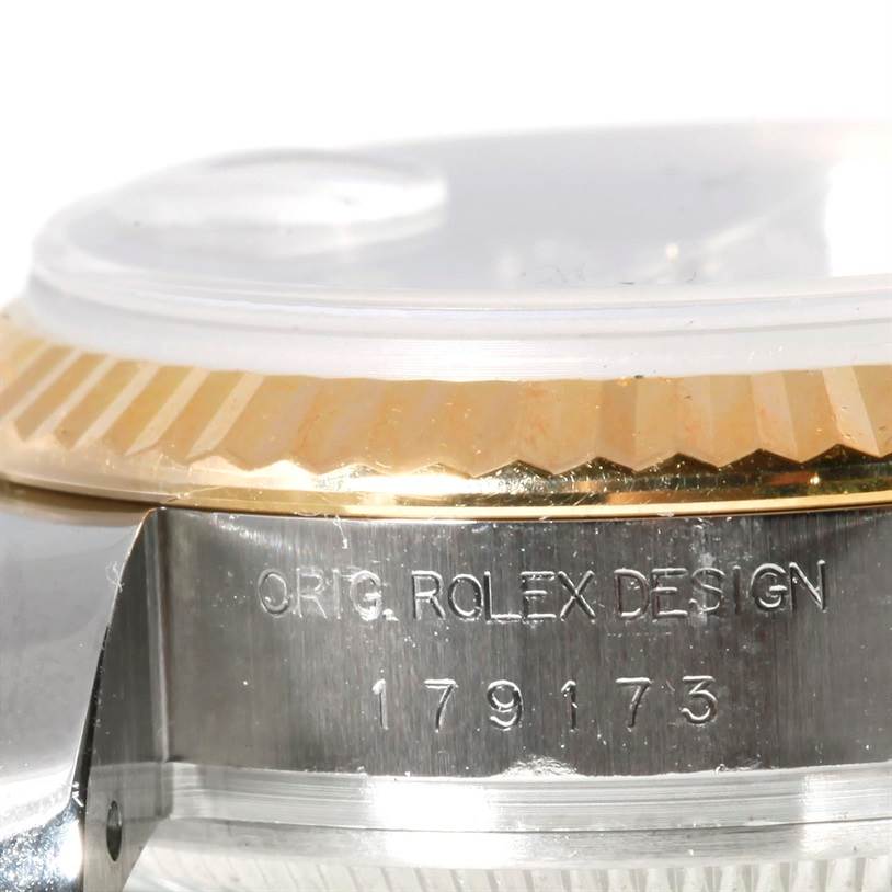 This image shows a close-up view of the side engraving and fluted bezel of a Rolex Datejust 179173 Women's Steel and Gold (two tone) Mother of Pearl Dial 179173 Women's Steel and Gold (two tone) Mother of Pearl Dial model.