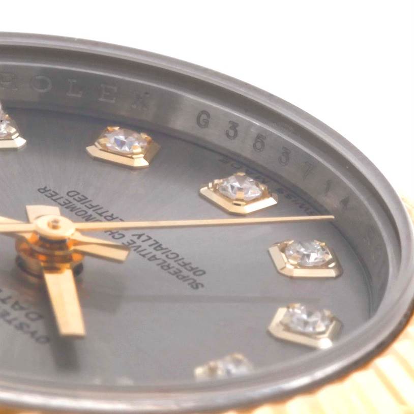 This close-up image of a Rolex Datejust 179173 Women's Steel and Gold (two tone) Grey Dial 179173 Women's Steel and Gold (two tone) Grey Dial watch shows the dial with diamond hour markers, part of the bezel, and the hands.