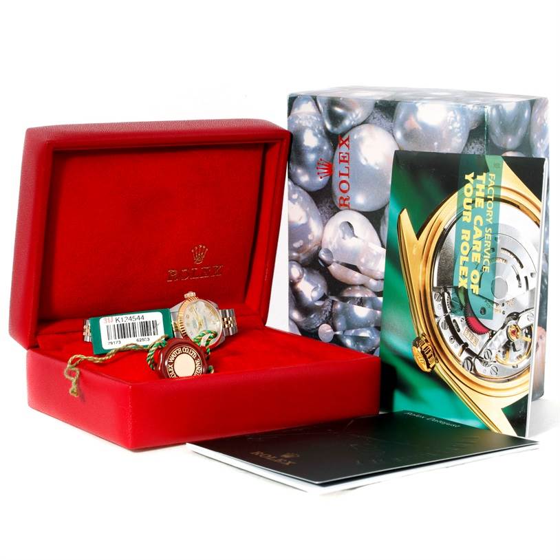 The image shows a Rolex Datejust 79173 Women
s Stainless Steel Silver Dial 79173 Women
s Stainless Steel Silver Dial watch in a red case, with tags and booklets displayed at an oblique angle.