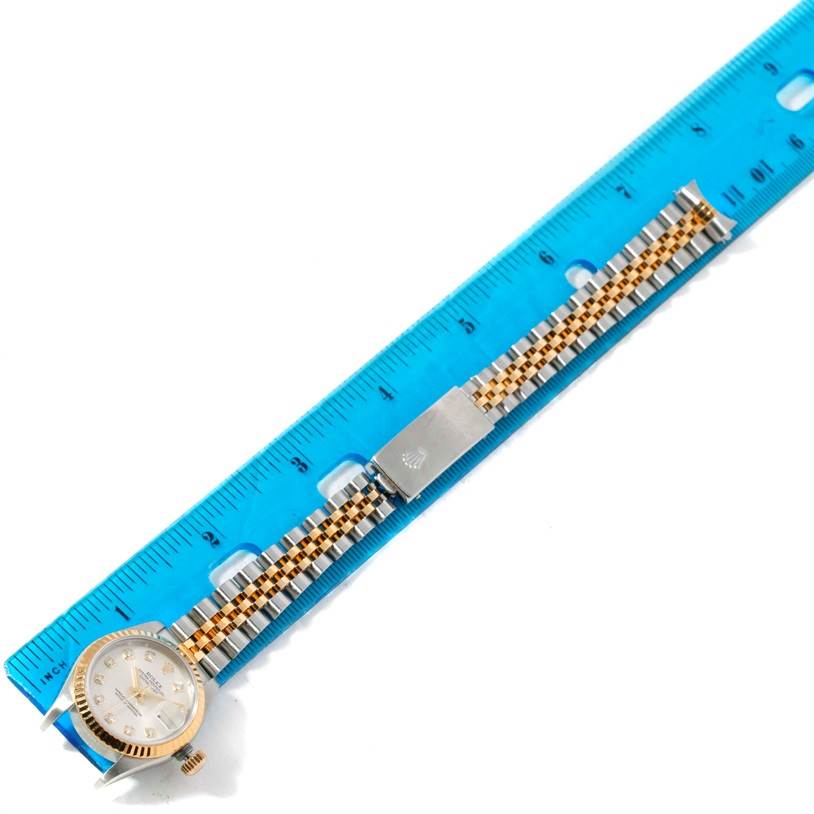 The image shows a Rolex Datejust 79173 Women
s Stainless Steel Silver Dial 79173 Women
s Stainless Steel Silver Dial watch, laying flat next to a blue ruler, displaying its dial and bracelet.