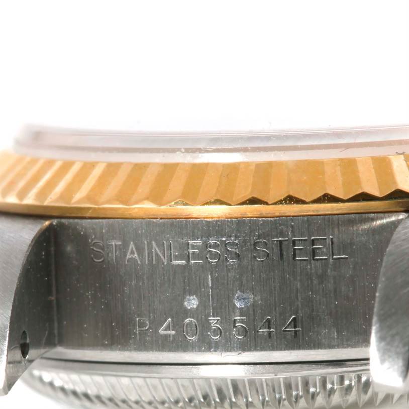 The image shows a close-up of the side of a Rolex Datejust 79173 Men
s Stainless Steel Champagne Dial 79173 Men
s Stainless Steel Champagne Dial watch, focusing on the stainless steel case and the edge of the bezel.