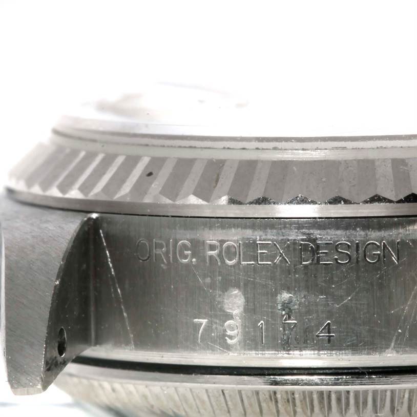 The image shows a close-up of the bezel and case with engraved serial number of a Rolex Datejust 79174 Women's Stainless Steel Pink Dial 79174 Women's Stainless Steel Pink Dial watch.