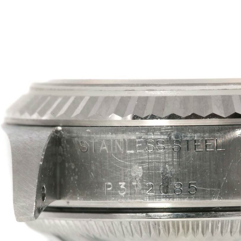 This image shows the side view of the casing and bezel of a Rolex Datejust 79174 Women's Stainless Steel Pink Dial 79174 Women's Stainless Steel Pink Dial with "STAINLESS STEEL" and a serial number engraved.