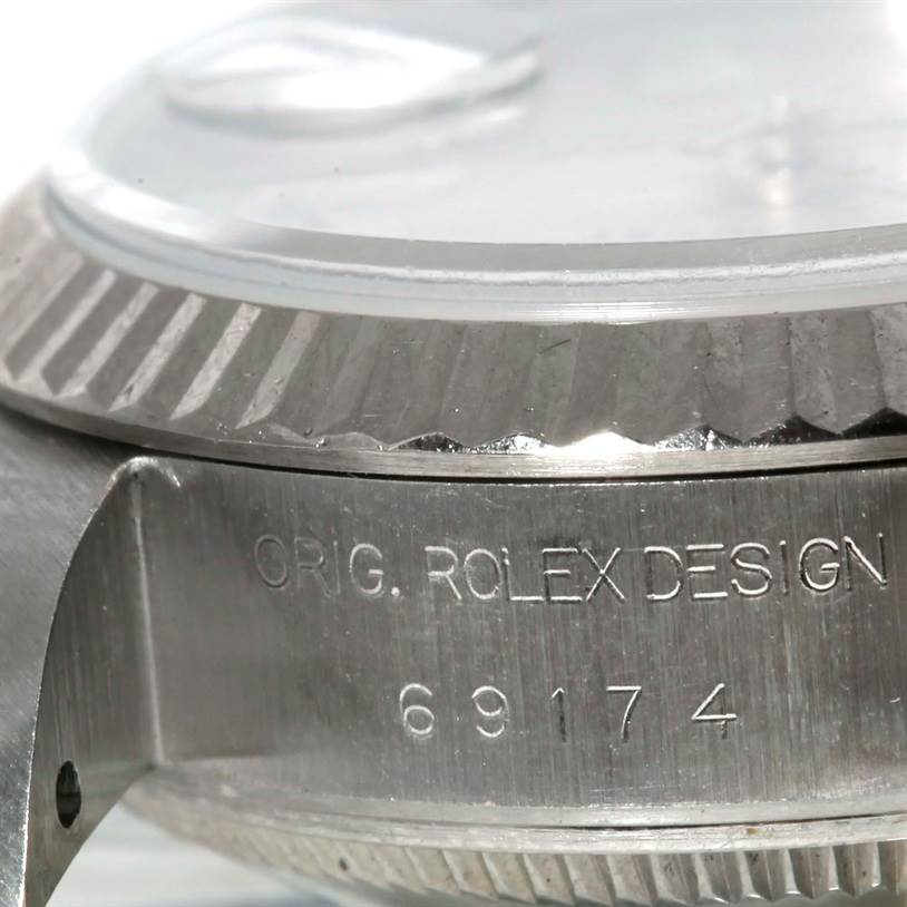 This image shows a close-up of the side case and bezel of a Rolex Datejust 69174 Women
s Stainless Steel Silver Dial 69174 Women
s Stainless Steel Silver Dial watch, revealing the model number and "ORIG. ROLEX DESIGN" engraving.