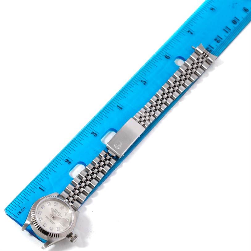 The Rolex Datejust 69174 Women
s Stainless Steel Silver Dial 69174 Women
s Stainless Steel Silver Dial watch is shown from a top view, displaying the face, bracelet, and clasp, alongside a blue ruler.