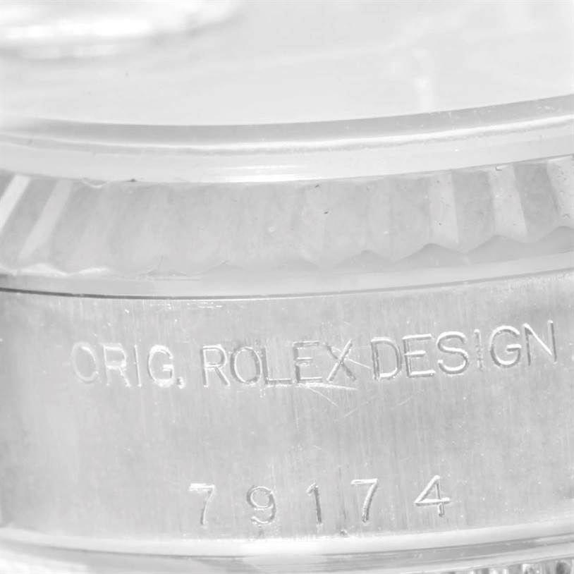 This close-up image shows the engraved casing with "ORIG. ROLEX DESIGN" and the model number "79174" on the Rolex Datejust 79174 Women's Stainless Steel Black Dial 79174 Women's Stainless Steel Black Dial watch.