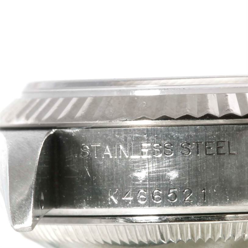 The image shows a close-up side view of a Rolex Datejust 79174 Women
s Stainless Steel Blue Dial 79174 Women
s Stainless Steel Blue Dial watch case, highlighting the stainless steel engraving and partial bezel.