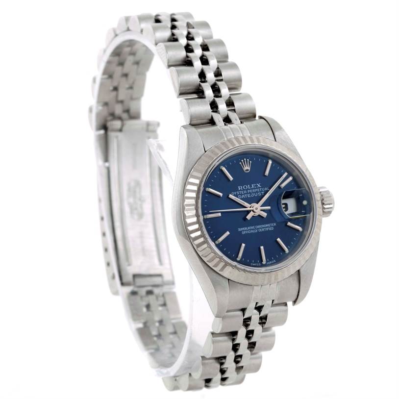The image shows a side angle view of a Rolex Datejust 79174 Women
s Stainless Steel Blue Dial 79174 Women
s Stainless Steel Blue Dial watch, highlighting its blue dial, fluted bezel, and jubilee bracelet.