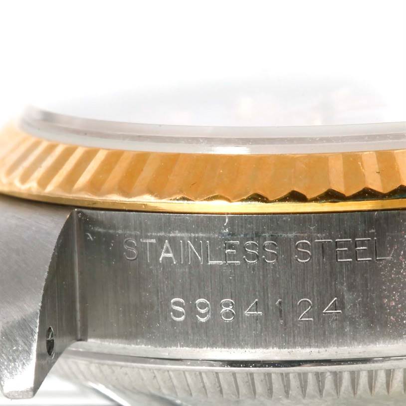 The image shows a close-up of the side and bezel of a Rolex Datejust 69173 Women's Stainless Steel White Dial 69173 Women's Stainless Steel White Dial, highlighting the stainless steel case and part of the gold bezel.