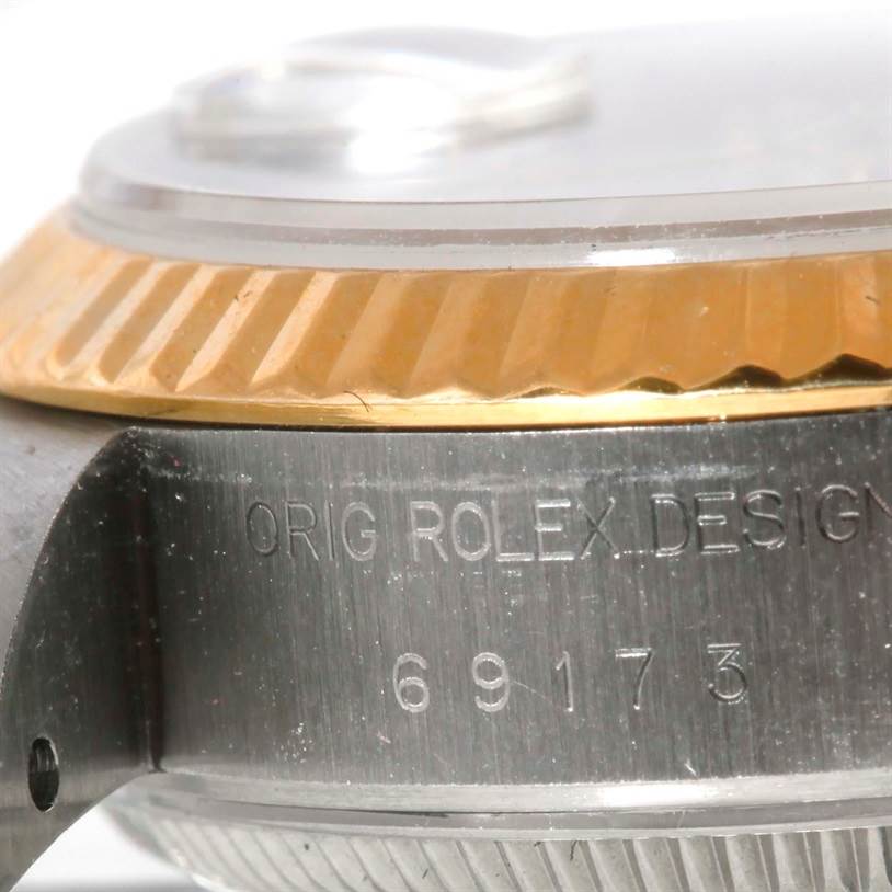 The image shows a close-up angle of a Rolex Datejust 69173 Women's Stainless Steel White Dial 69173 Women's Stainless Steel White Dial watch focusing on the side with engraved model details and part of the bezel.