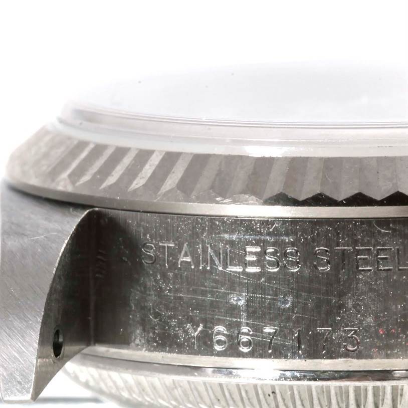 This image shows a close-up of the side of a Rolex Datejust 79174 Women's Stainless Steel Silver Dial 79174 Women's Stainless Steel Silver Dial watch, highlighting the bezel, case, and part of the serial number engraving.