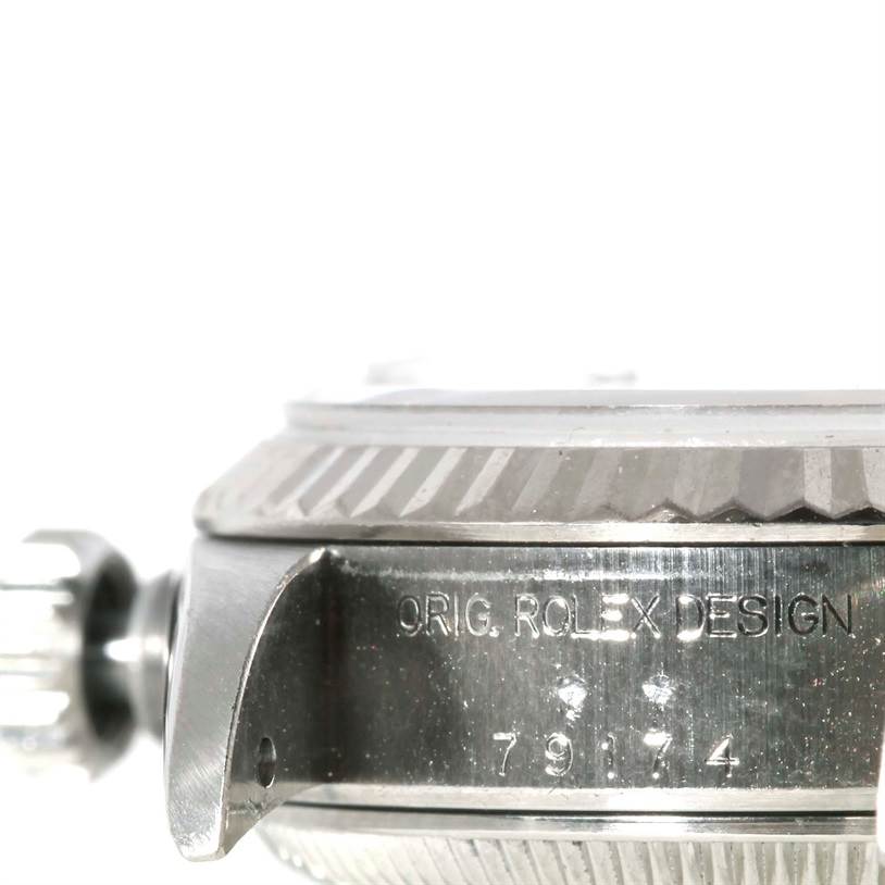 The image shows a side view of the crown and case of a Rolex Datejust 79174 Women's Stainless Steel Blue Dial 79174 Women's Stainless Steel Blue Dial watch with "ORIG. ROLEX DESIGN" etched on it.