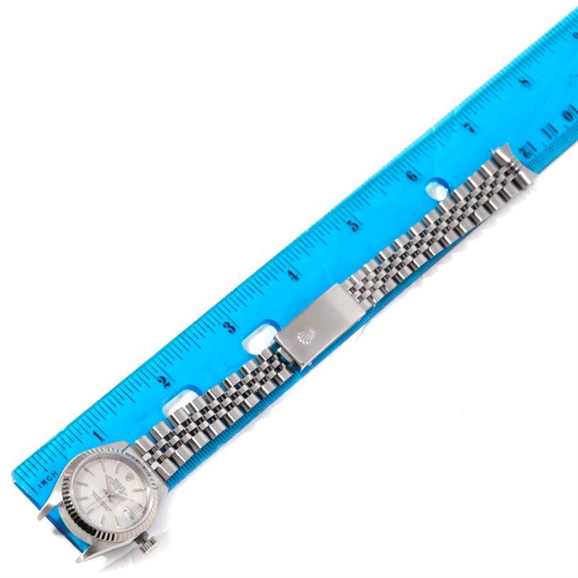 The image shows a Rolex Datejust 79174 Women's Stainless Steel Silver Dial 79174 Women's Stainless Steel Silver Dial watch laid flat with its case, dial, and bracelet visible alongside a blue ruler.