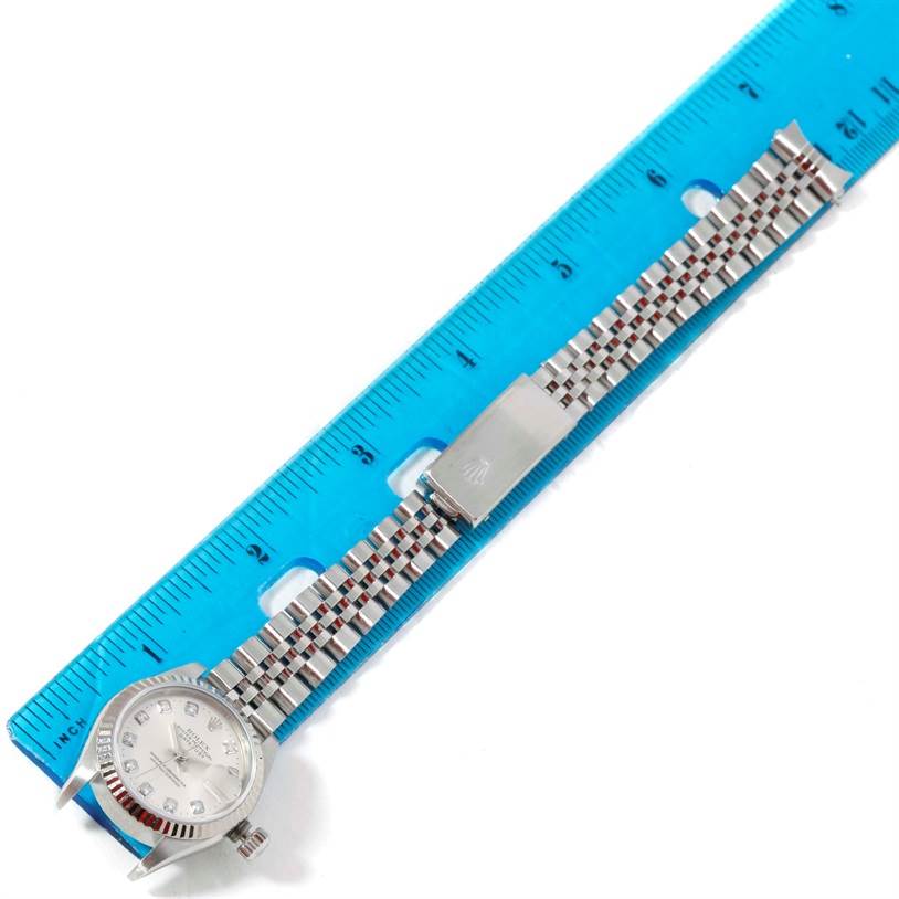 The Rolex Datejust 79174 Women's Stainless Steel Silver Dial 79174 Women's Stainless Steel Silver Dial watch is shown flat with the face, bracelet, and clasp visible, measured against a blue ruler.