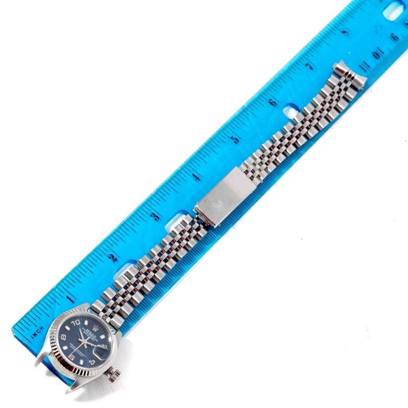 The image shows a top-down view of a Rolex Datejust 69174 Women's Stainless Steel Blue Dial 69174 Women's Stainless Steel Blue Dial watch with a ruler for scale, highlighting both the watch face and the bracelet.