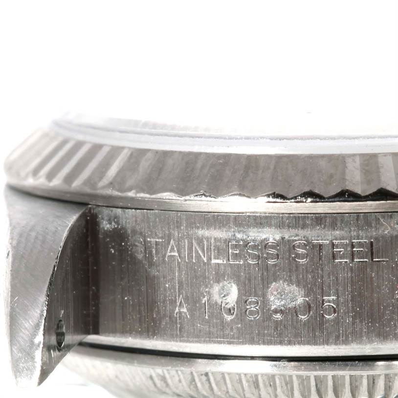 The image shows a close-up of the side view of a Rolex Datejust 69174 Women's Stainless Steel Blue Dial 69174 Women's Stainless Steel Blue Dial model, focusing on the bezel and the stainless steel case.