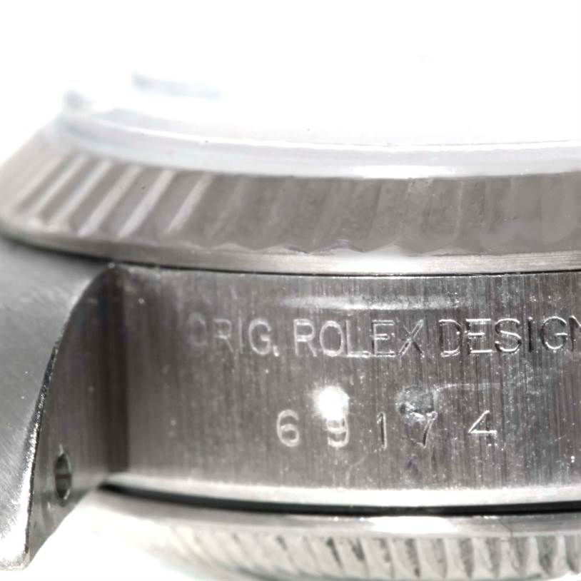 This close-up image shows the Rolex Datejust 69174 Women's Stainless Steel Blue Dial 69174 Women's Stainless Steel Blue Dial model's case side with engravings and part of the bezel and lug.